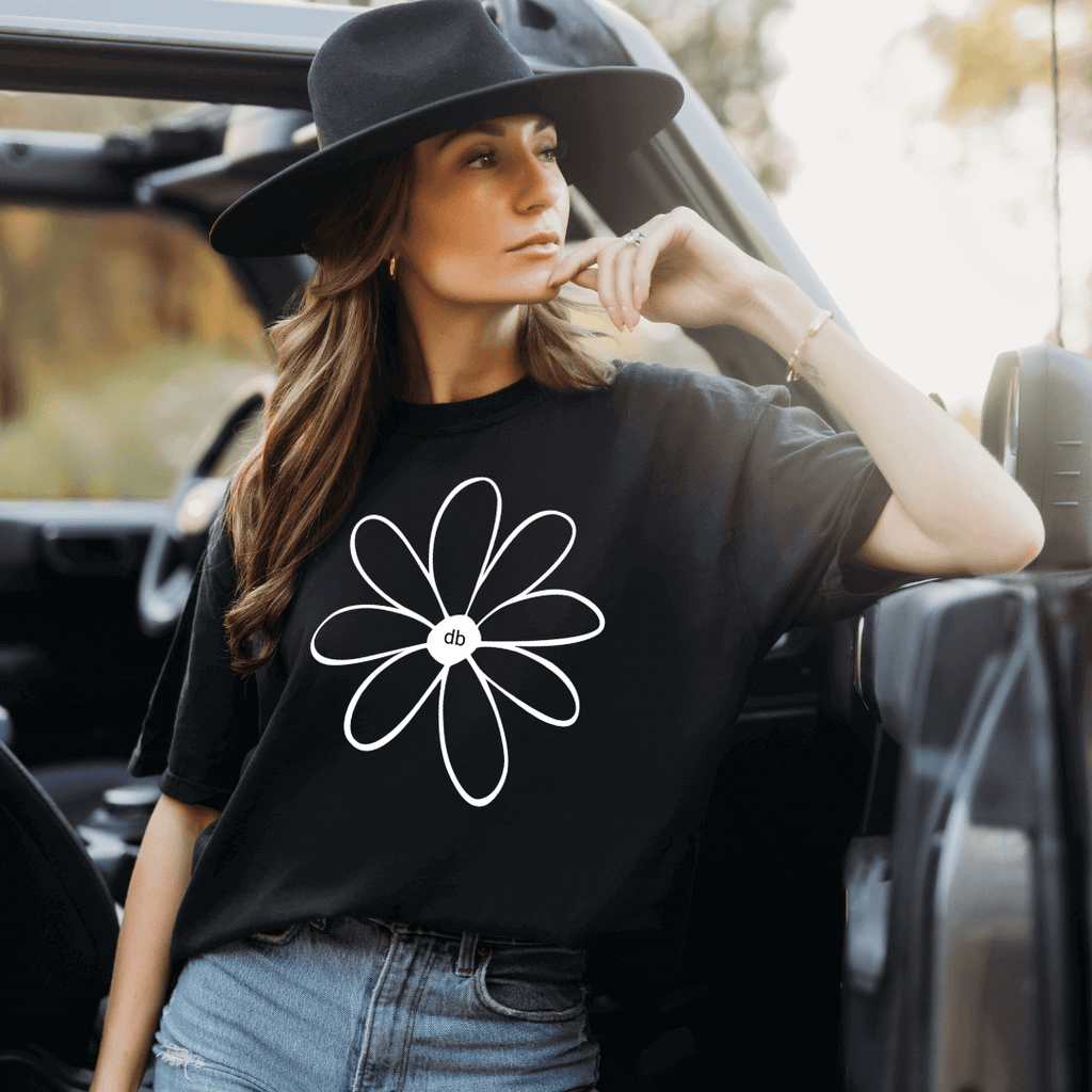  Cool looking model wearing Daisy-Bella Positive Vibe Daisy Screen T-shirt with large black rim hat - tee color is black with white daisy screen