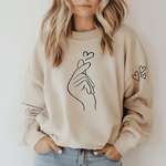 <img src="love-sand-sweatshirt.jpg" alt="Love Sand Inspirational Sweatshirt in a soft neutral tone with black graphics - hand with snap & hearts">