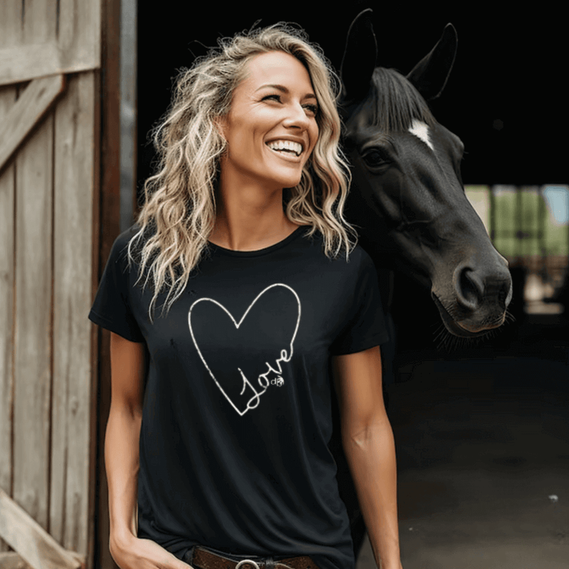 Heartfelt Love Inspirational T-shirt on model standing in Barn with horse - Tee is black with white screen