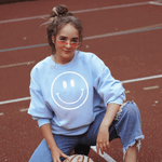 Smiley Face sweatshirt in soft blue color on a woman with boho vintage inspiration.