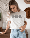 Inspirational Shirt with graphics - saying Rebel in stone color on model in jeans