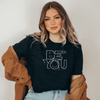 Be You inspirational t-shirt in black color on a woman sitting in a boho atmosphere