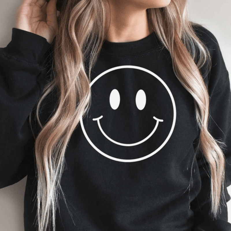 Smiley Face inspired sweatshirt on a woman standing in black color